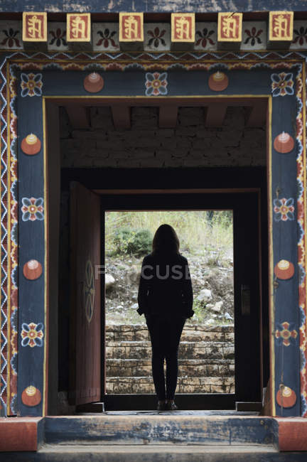 Femme debout dans une porte — Photo de stock