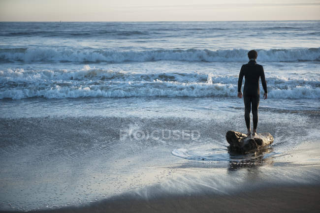 Силует людини, що стоїть на пляжі, дивлячись Out над океаном — стокове фото