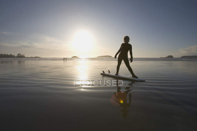 Silhouette di surfista femminile che fa esercizi di yoga; Chesterman Beach, Tofino, Vancouver Island, British Columbia, Canada — Foto stock