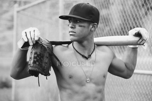 Молодой взрослый многорасовый мужчина с бейсбольной экипировкой, монохромное изображение — стоковое фото