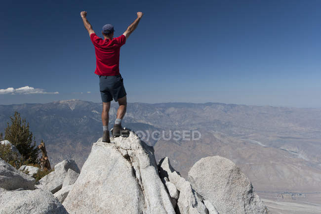Escursionista maschio con le braccia sollevate — Foto stock