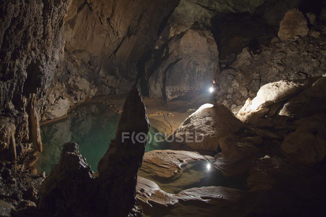 Guide philippin tenant une lanterne à l'intérieur de la grotte de Sumaging ou Big Cave près de Sagada, Luçon, Philippines — Photo de stock