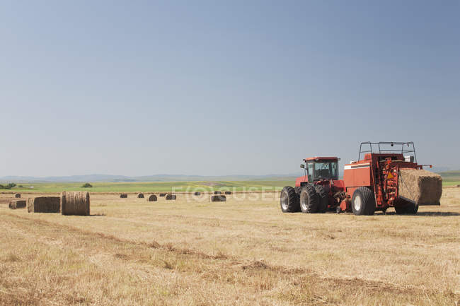Hay Baler in a field with Blue Sky — стоковое фото