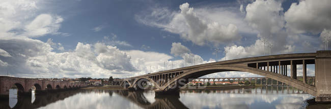 Puentes con nubes reflejadas en el agua - foto de stock
