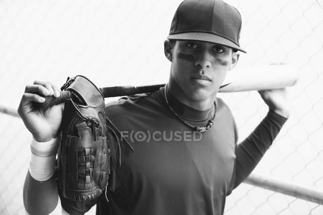 Jeune homme multiracial adulte avec batte de baseball regardant la caméra — Photo de stock