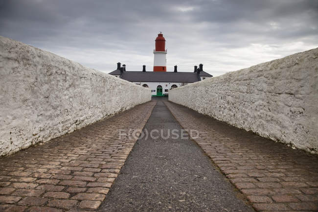 Путь к красно-белому маяку — стоковое фото