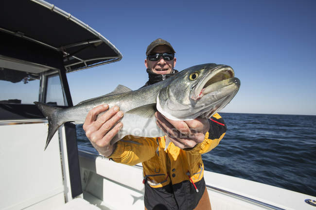 Fischer hält mit Stolz seinen frischen Fang in der Hand. montauk, new york, vereinigte staaten von amerika — Stockfoto