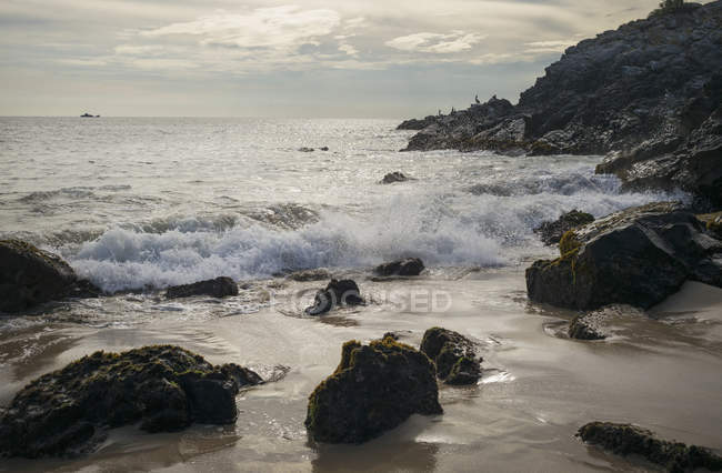 Rocky coast and ship in distance — Stock Photo