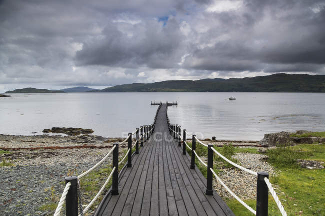 Wooden walkway leading to water — Stock Photo