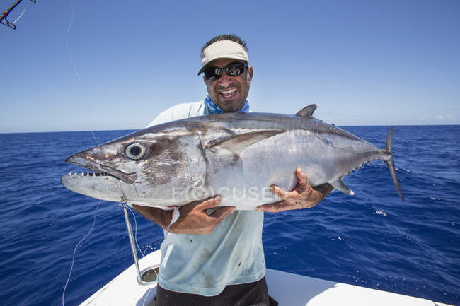 Fisherman on boat holding fresh caught Dogtooth Tuna — Stock Photo