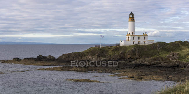 Lighthouse on coast against water — Stock Photo