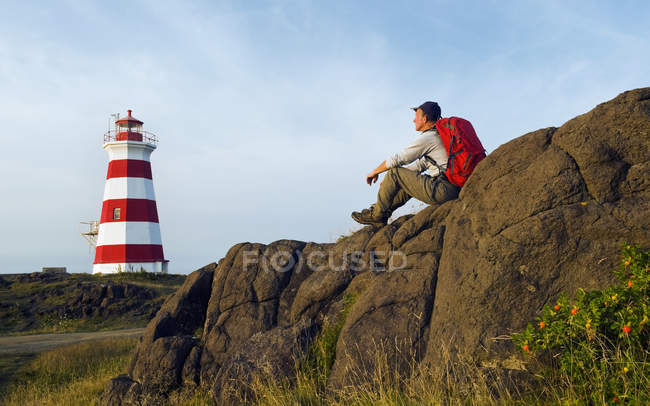 Hiker looking out over lighthouse, bay of fundy, nova scotia, canada — Stock Photo