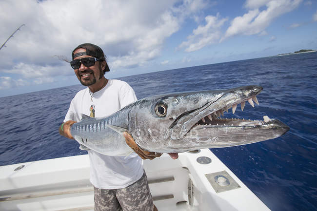 Pescador sosteniendo peces barracuda. Tahití - foto de stock