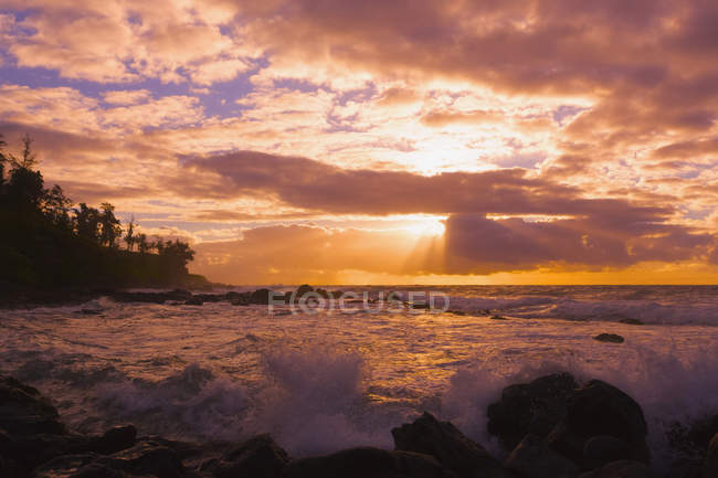 Sunrise and waves crashing on the rocks — Stock Photo