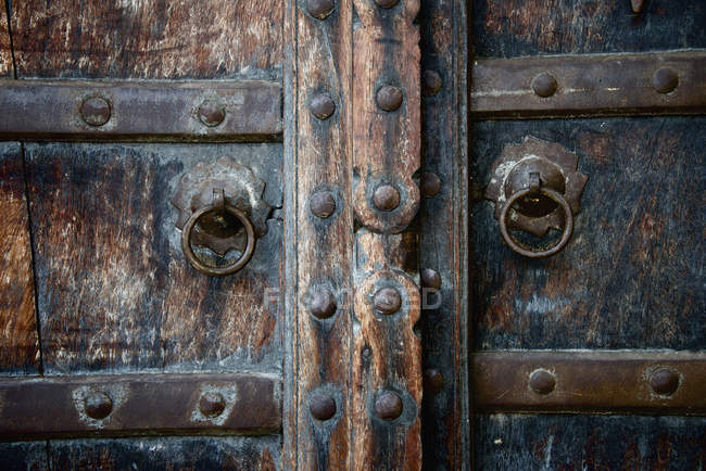 Fechar as portas de madeira velhas com anéis de latão — Fotografia de Stock