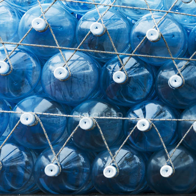 Голубые пластиковые контейнеры для воды с белыми крышками, прикрепленными веревкой; Сеул, Южная Корея — стоковое фото