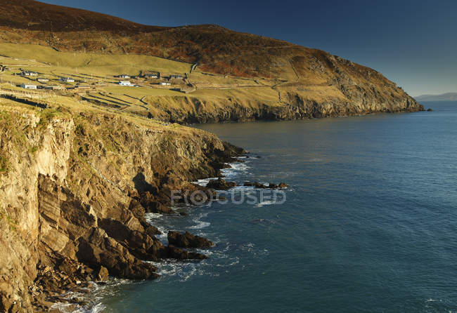Beach with cliffs and green grass — Stock Photo