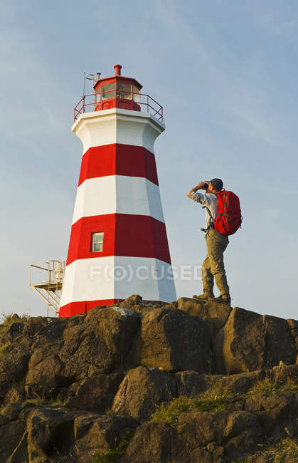 Hiker looking out over Brier Island Lighthouse, Bay of Fundy. Brier Island, Nova Scotia, Canada — Stock Photo