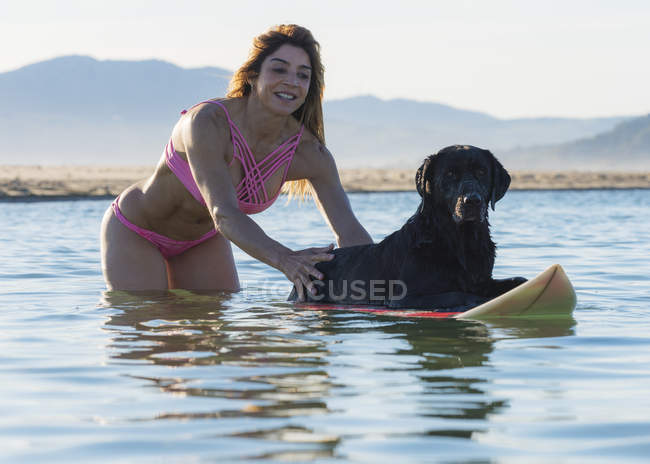 Frau hat Spaß mit ihrem Hund im Wasser; tarifa, cadiz, costa de la luz, andalusia, spanien — Stockfoto