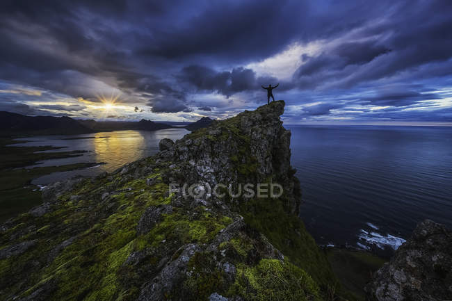 Homme debout au sommet de la falaise — Photo de stock