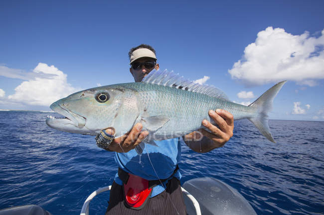 Pescador sosteniendo pescado fresco capturado Jobfish. Tahití - foto de stock