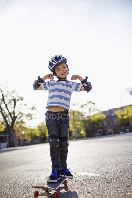 Jovem ásia menino equitação no skate no parque — Fotografia de Stock