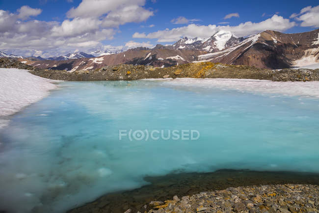 Pool of water lies on snow — Stock Photo