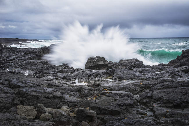 Éclaboussures de vagues contre les roches — Photo de stock
