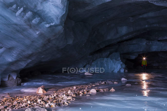 Uomo in grotta di ghiaccio presso Augustana Glacier in Alaska Range, Alaska, Stati Uniti d'America — Foto stock
