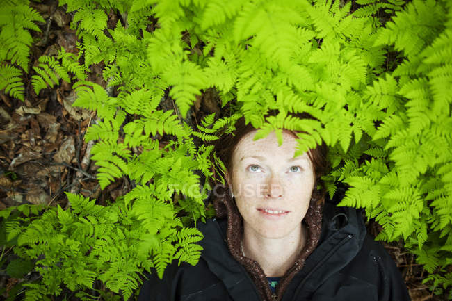 Portrait of woman with red hair and forest in the background — Stock Photo