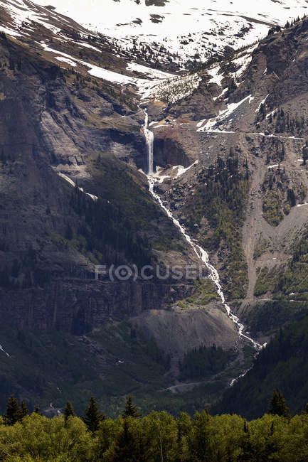 Cascada de montaña lejana - foto de stock
