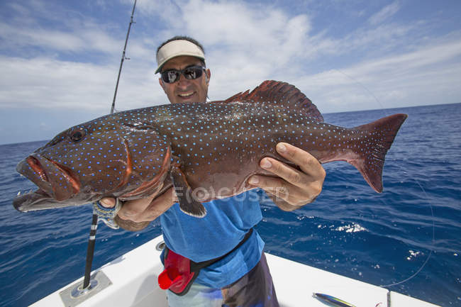 Fisherman on boat holding fresh caught Grouper — Stock Photo