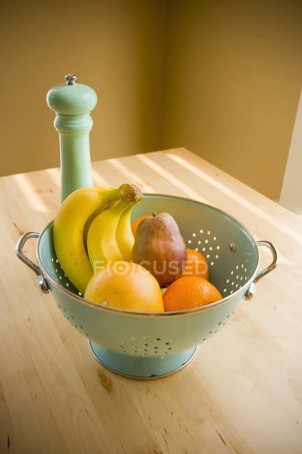 Sieb mit Früchten über dem Tisch — Stockfoto