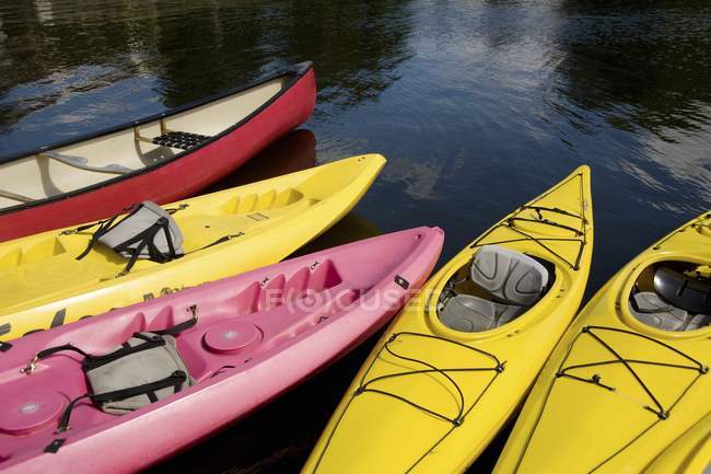 Kayaks coloridos vacíos a la deriva en el agua - foto de stock
