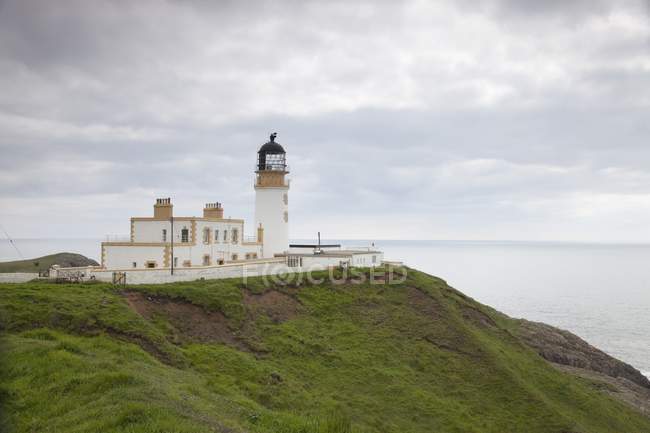Lighthouse on green grass hill — Stock Photo