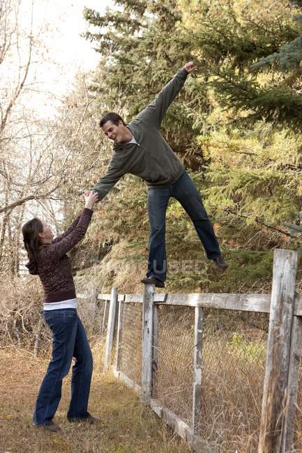Joven atractivo caucásico pareja siendo juguetón en otoño parque - foto de stock