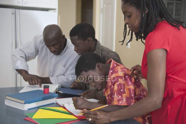 Pais africanos americanos ajudando seus filhos com lição de casa — Fotografia de Stock