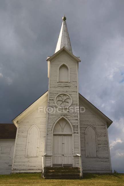 Chiesa di legno intemperie sotto cieli bui — Foto stock