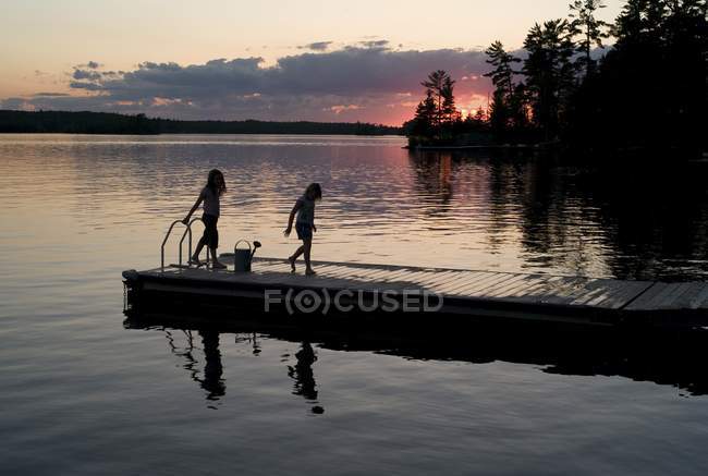 Lake Of The Woods, Ontario, Canada; Two Girls On A Dock — Stock Photo