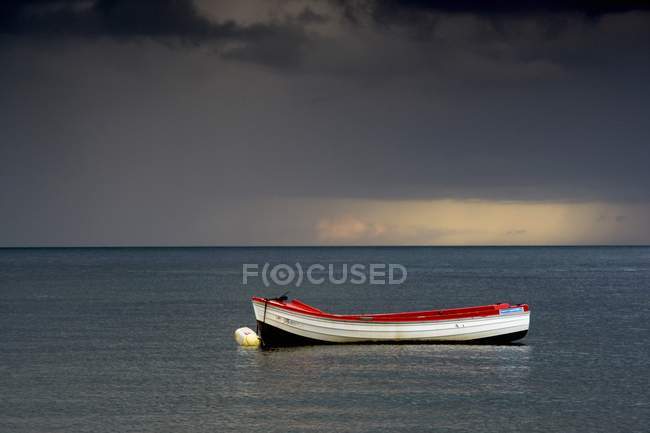 Barco vacío flotando en el mar - foto de stock