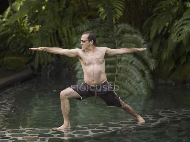 Como Shambhala Estate, Bali, Indonesia; Hombre en posición de yoga - foto de stock