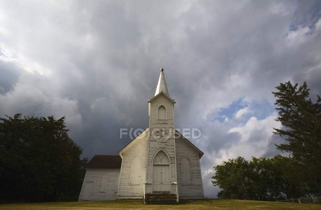 Igreja desgastada e céus escuros — Fotografia de Stock