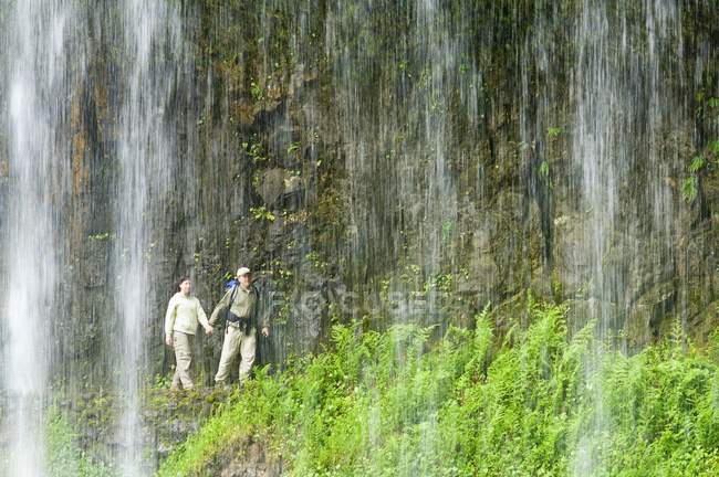 Escursionisti a piedi vicino al muro di pietra — Foto stock