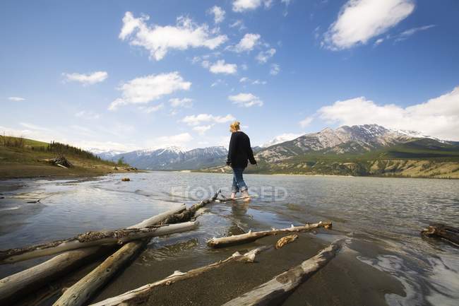 Woman walking By River with hills on background Jasper, Alberta, Canadá — Fotografia de Stock