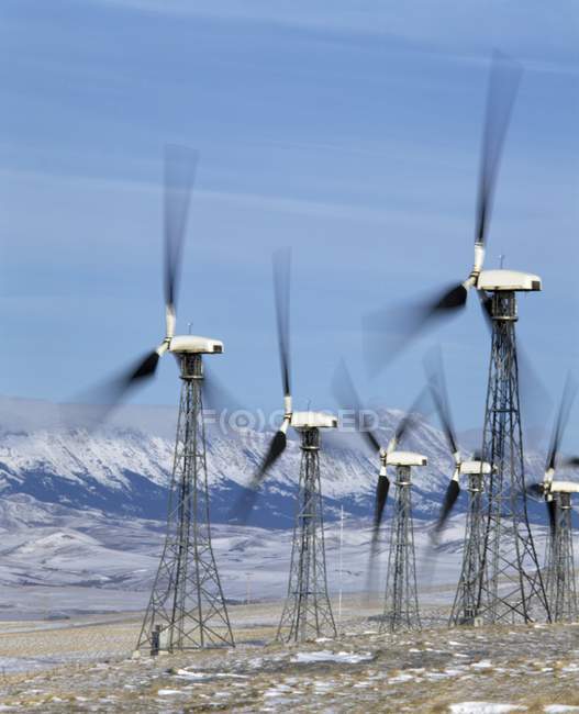 Turbinas eólicas frente a las montañas - foto de stock