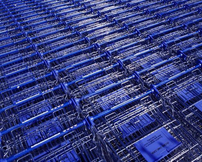 Stacks of metal shopping trolleys background — Stock Photo