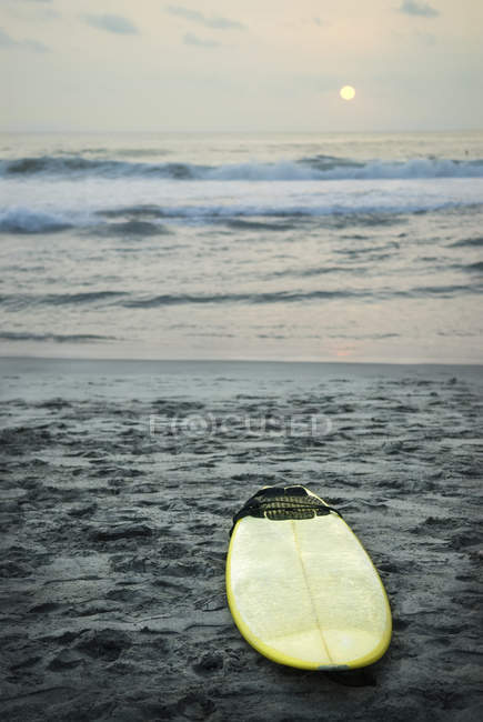 Tabla de surf acostado en la arena - foto de stock