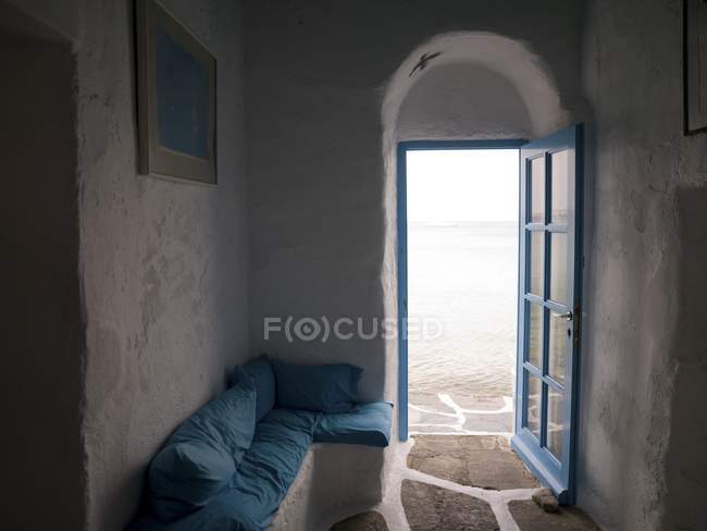 Дверь и диван у стены — стоковое фото