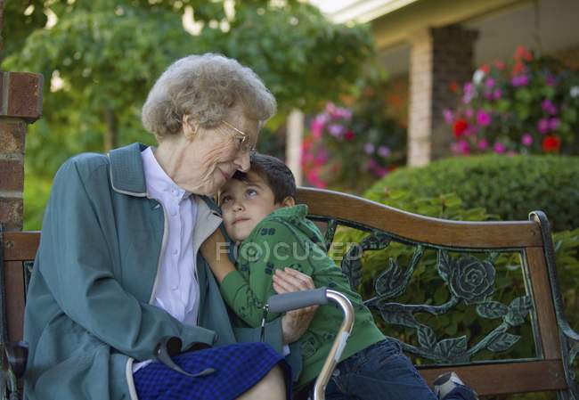 Бабуся і онук обіймати в саду — стокове фото