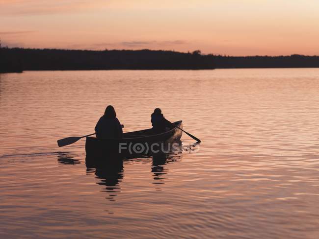 Remo en el lago al atardecer, Lago de los Bosques, Ontario, Canadá - foto de stock
